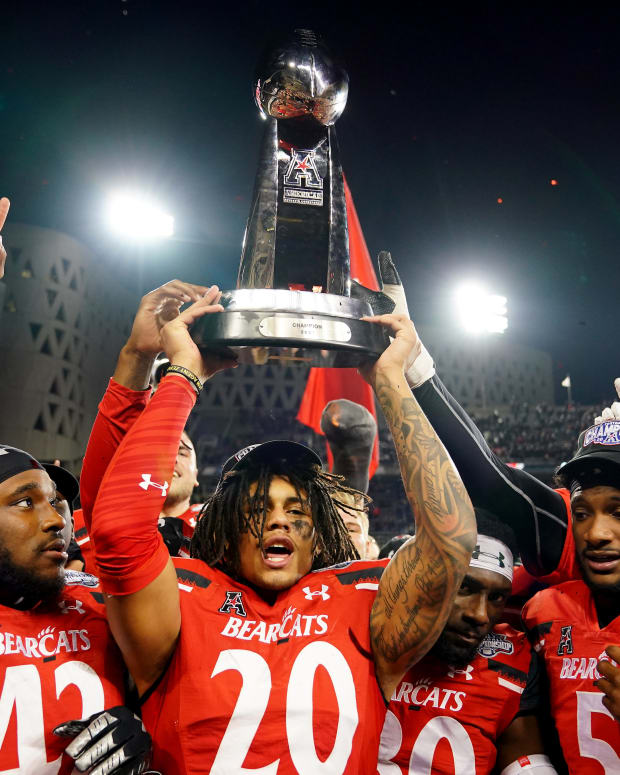 Cincinnati Bearcats linebacker Deshawn Pace (20) raises the trophy of the American Athletic Conference championship football game, Saturday, Dec. 4, 2021, at Nippert Stadium in Cincinnati. The Cincinnati Bearcats defeated the Houston Cougars, 35-20. Houston Cougars At Cincinnati Bearcats Aac Championship Dec 4