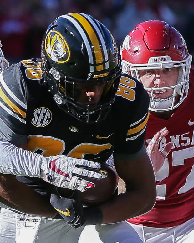 Missouri wide receiver Tauski Dove tries to shake free from Hayden Henry and Montaric Brown against Arkansas in a 2021 loss.
