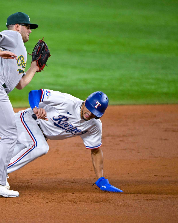 Aug 17, 2022; Arlington, Texas, USA; Texas Rangers center fielder Bubba Thompson (65) steals second base past Oakland Athletics second baseman Jonah Bride (77) during the second inning at Globe Life Field. Mandatory Credit: Jerome Miron-USA TODAY Sports