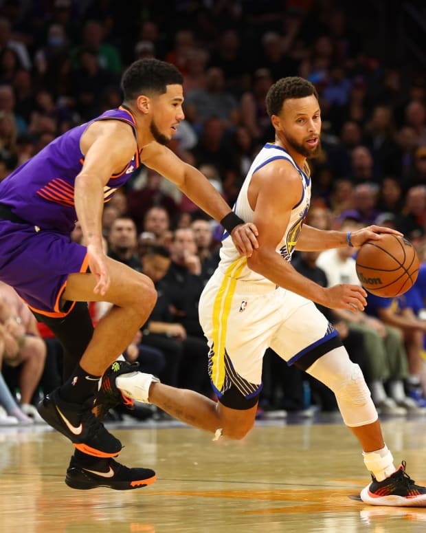 Phoenix Suns guard Devin Booker defends Golden State Warriors guard Stephen Curry.