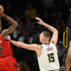 Denver Nuggets center Nikola Jokic (15) puts his hand on the chest of Toronto Raptors forward Precious Achiuwa (5) as he takes a shot during the first quarter at Ball Arena