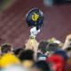 California Golden Bears helmet is raised into the air amongst fans after defeating the Stanford Cardinal at Stanford Stadium.