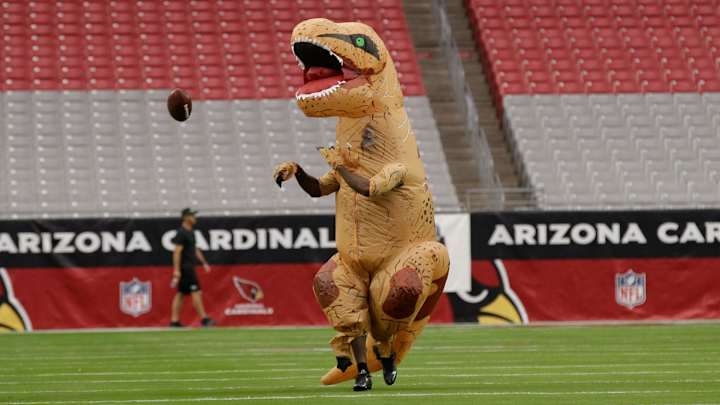 Patrick Peterson lost a contest, so he warmed up in a dinosaur costume Patrick Peterson lost a contest, so he warmed up in a dinosaur costume