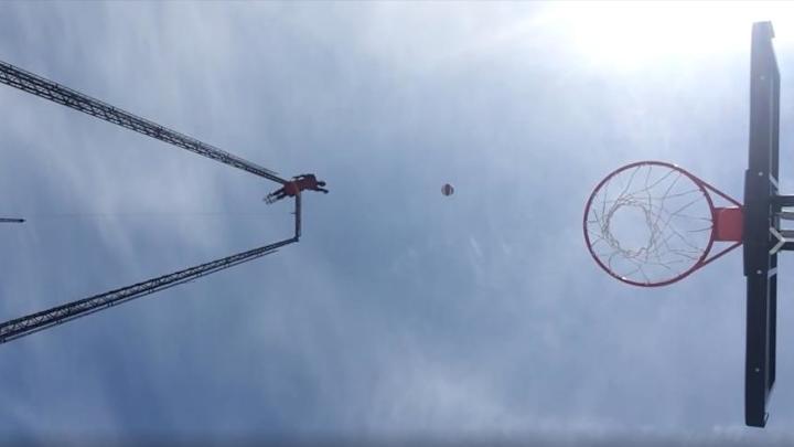 Harlem Globetrotter hits trick shot while swinging 110 feet in the air