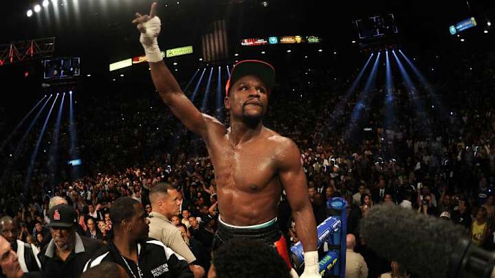 Floyd Mayweather works out while holding a stack of cash
