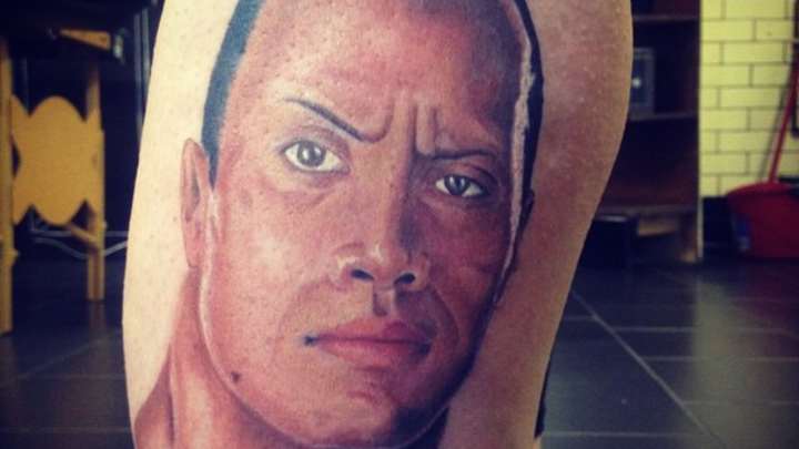 This person has an enormous tattoo of The Rock's face on their leg