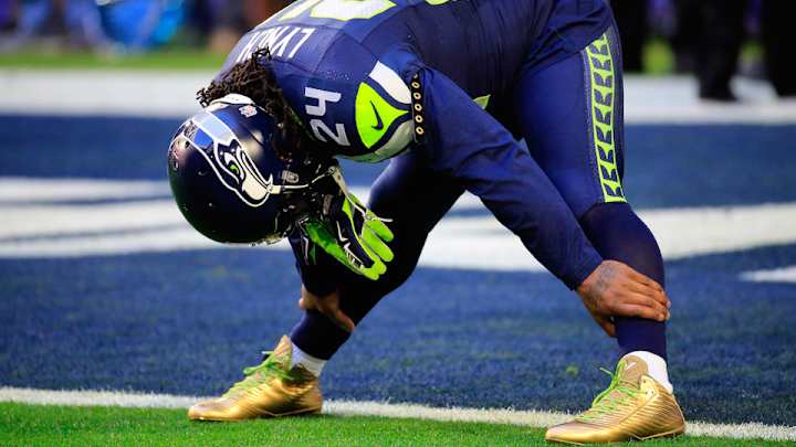 Marshawn Lynch sports gold cleats for Super Bowl warmups Marshawn Lynch sports gold cleats for Super Bowl warmups