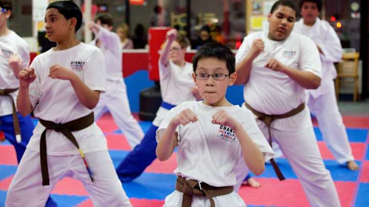 Young taekwondo student struggles mightily to kick through board