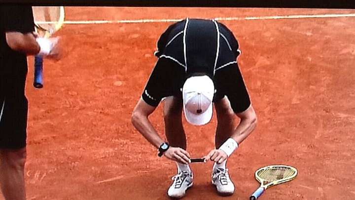 Bob Bryan takes photo of ball mark during French Open doubles match