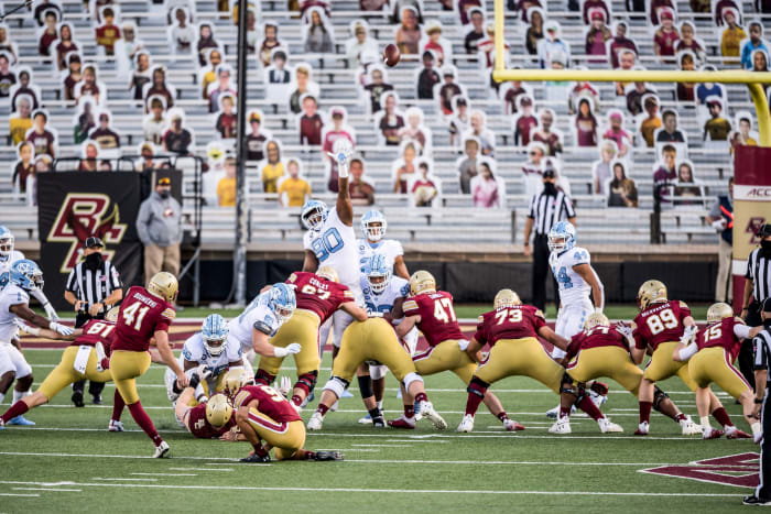 Boston College kicks a field goal as cutouts of fans look on