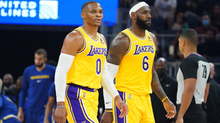 Los Angeles Lakers guard Russell Westbrook and forward LeBron James walk to the bench