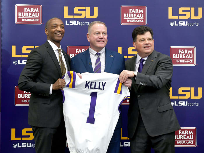 Brian Kelly poses with LSU president William Tate IV (left) and AD Scott Woodward (right)