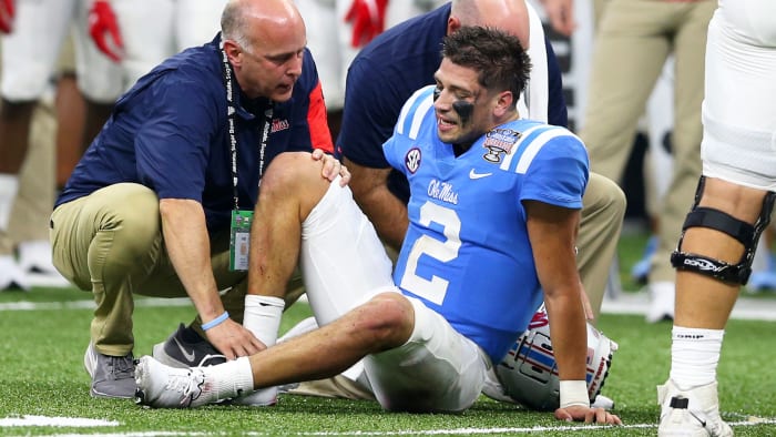 Ole Miss QB Matt Corral gets checked out by a trainer