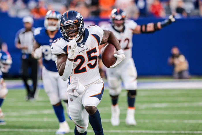 Denver Broncos running back Melvin Gordon (25) holds the ball for a rushing touchdown during the second half in front of New York Giants nose tackle Austin Johnson (98) at MetLife Stadium.