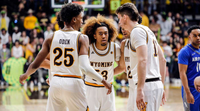 Wyoming guard Xavier DuSell (53), Wyoming forward Jeremiah Oden (25), and Wyoming forward Hunter Thompson (10) huddle after a foul during the second half of an NCAA college basketball game against Air Force, Saturday, Feb.  19, 2022, in Laramie, Wyo.