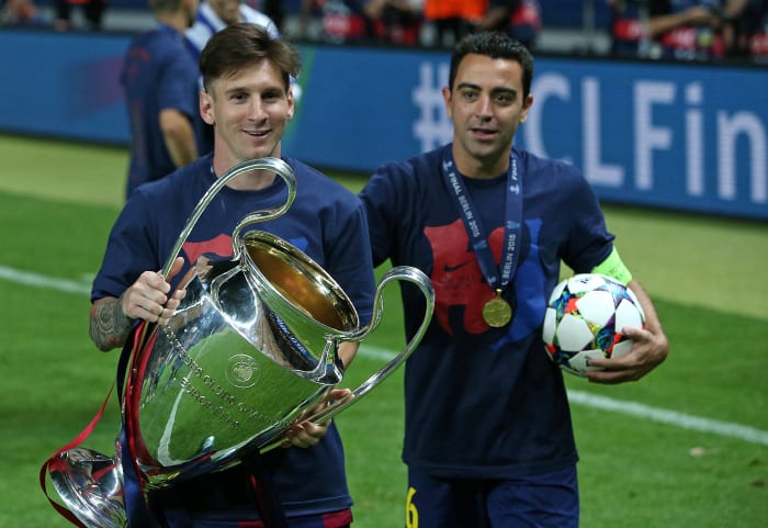 Lionel Messi détient le trophée de la Ligue des champions aux côtés de son coéquipier barcelonais Xavi Hernandez en 2015