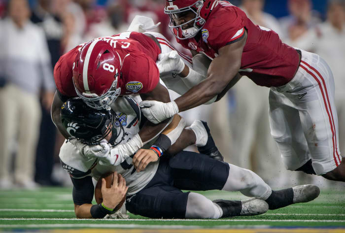 Cincinnati Bearcats quarterback Desmond Ridder (9) is sacked by Alabama Crimson Tide linebacker Christian Harris (8) during the third quarter of the 2021 Cotton Bowl College Football National Semifinals at AT&T Stadium.