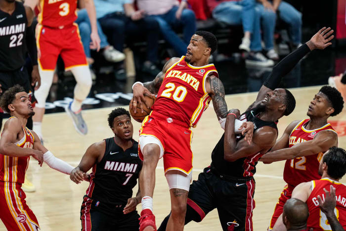 Apr 22, 2022; Atlanta, Georgia, USA; Atlanta Hawks forward John Collins (20) fights for a rebound with Miami Heat guard Kyle Lowry (7) and center Bam Adebayo (13) during the second half during game three of the first round of the 2022 NBA playoffs at State Farm Arena.