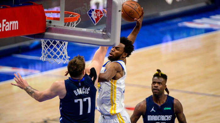 Golden State Warriors forward Andrew Wiggins (22) dunks the ball into the Dallas Mavericks girdle Luka Doncic.