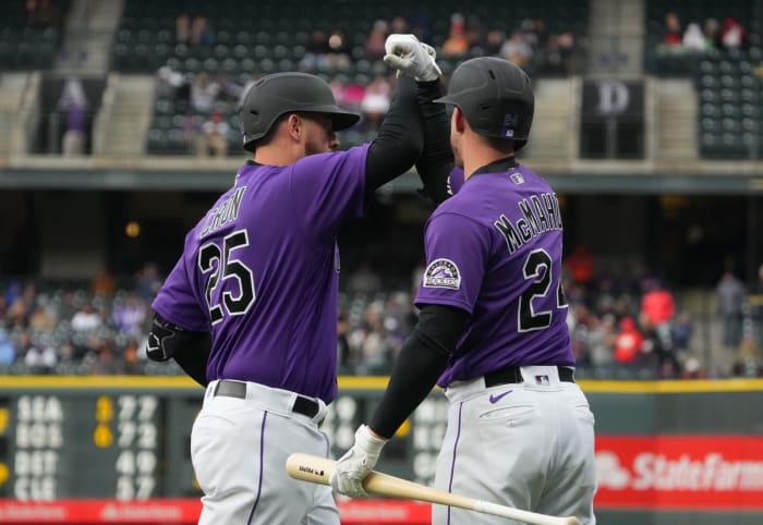 May 21, 2022;  Denver, Colorado, United States;  Colorado Rockies first baseman CJ Cron (25) celebrates with second baseman Ryan McMahon (24) after hitting a two-run home run against the New York Mets in the first inning at Coors Field.  Mandatory Credit: Ron Chenoy-USA TODAY Sports
