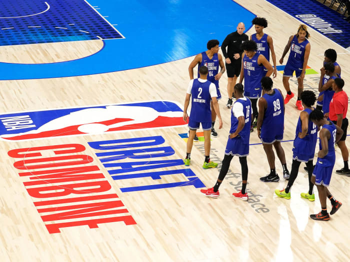 Los jugadores se paran junto al logotipo de la cosechadora del draft de la NBA