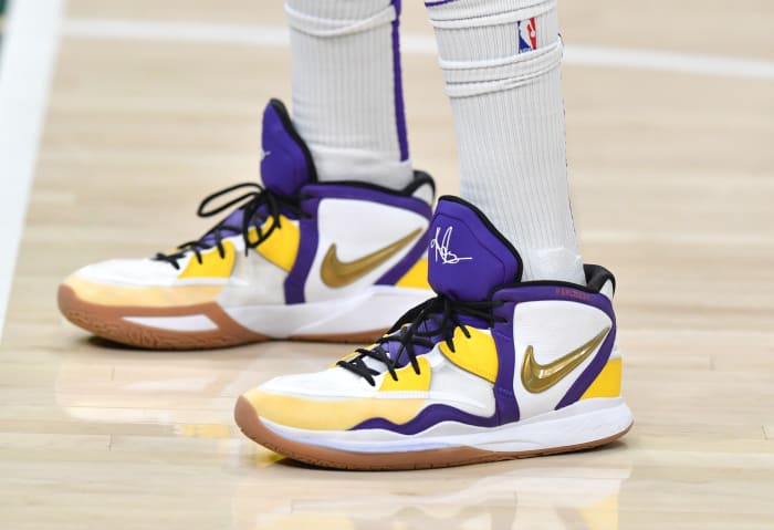 View of white, purple and gold Nike Kyrie shoes.