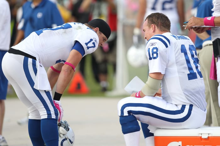 Austin Collie and Peyton Manning talk on the bench during a Colts game in 2010