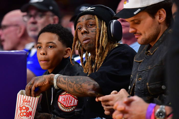 Lil Wayne watches a Lakers game from courtside seats.