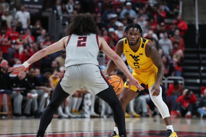 25 de enero de 2023;  Lubbock, Texas, Estados Unidos;  El escolta de los West Virginia Mountaineers, Joe Toussaint (5), regatea contra el escolta de los Texas Tech Red Raiders, Pop Isaacs (2), en la primera mitad en el United Supermarkets Arena.