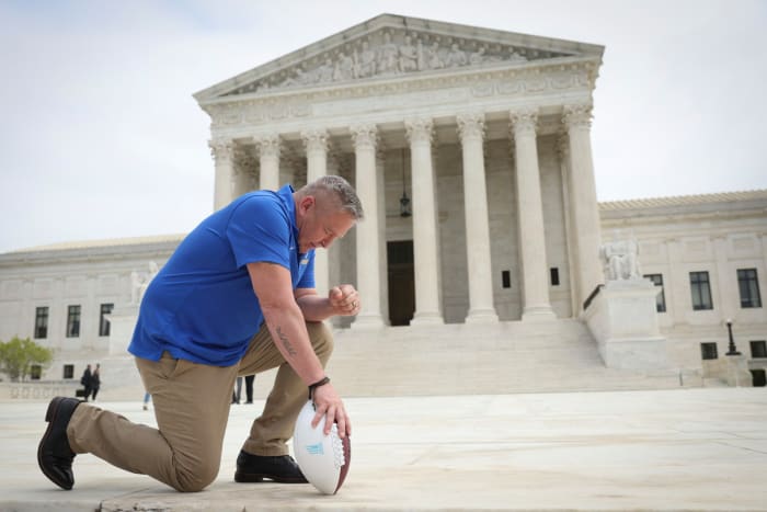 Joe Kennedy kneels in prayer in front of the U.S. Supreme Court Building
