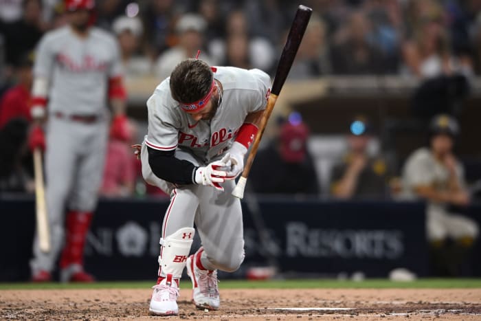 Bryce Harper falls to the ground after suffering a blow to his thumb.