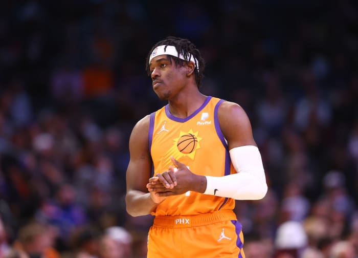 Aaron Holiday standing in Phoenix Suns uniform.