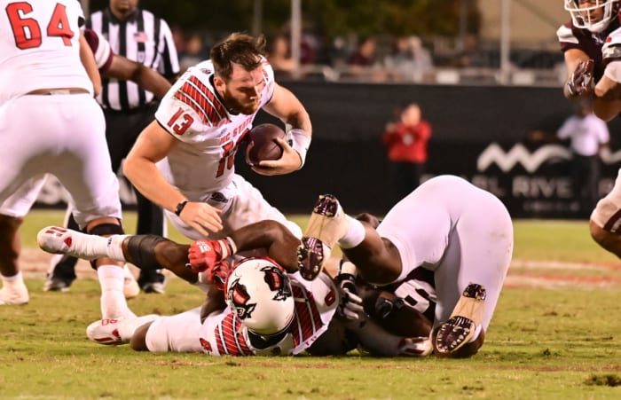 09/11/2021;  Starkville, Mississippi, USA;  North Carolina State Wolfpack quarterback Devin Leary (13) loses his helmet after being hit by Mississippi State Bulldogs defensive tackle Jaden Crumedy (94) in the fourth quarter at Davis Wade Stadium in Scott Field.  Mandatory Credit: Matt Bush-USA TODAY Sports