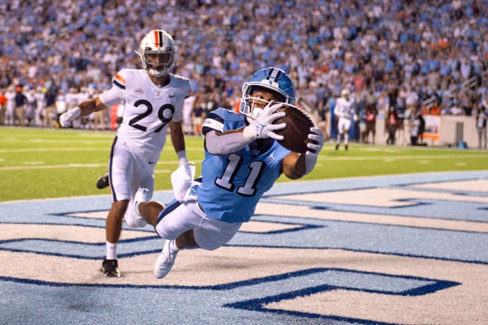 North Carolina Tar Heels wide receiver Josh Downs (11) catches a touchdown in the end zone as Virginia Cavaliers free safety Joey Blount (29) defends in the first quarter at Kenan Memorial Stadium.