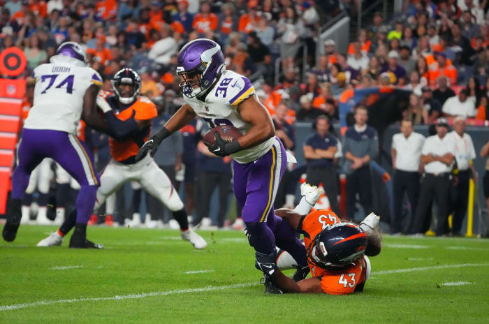 Minnesota Vikings running back Bryant Koback (38) is tackled by Denver Broncos linebacker Kana'i Mauga (43) in the second quarter at Empower Field at Mile High.
