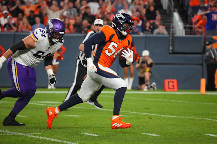 Denver Broncos linebacker Baron Browning (56) picks up a fumble and attempts a touchdown against Minnesota Vikings offensive tackle Blake Blundell (64) in the second quarter at Empower Field at Mile High.