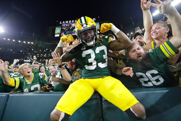 Green Bay Packers running back Aaron Jones, 33, celebrates with fans after scoring a second quarter touchdown against the Chicago Bears during a football game.