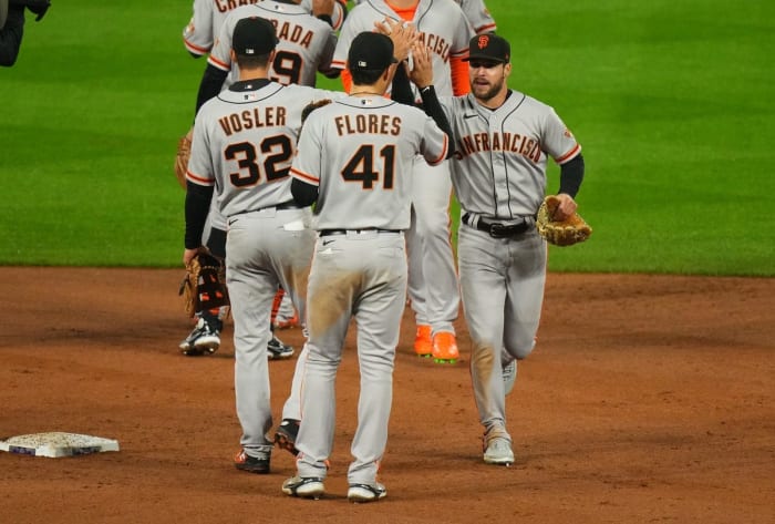 09/21/2022;  Denver, Colorado, United States;  San Francisco Giants right fielder Luis Gonzalez (51) and third baseman Jason Vosler (32) and San Francisco Giants second baseman Wilmer Flores (41) celebrate defeating the Colorado Rockies at Coors Field.  Mandatory Credit: Ron Chenoy-USA TODAY Sports