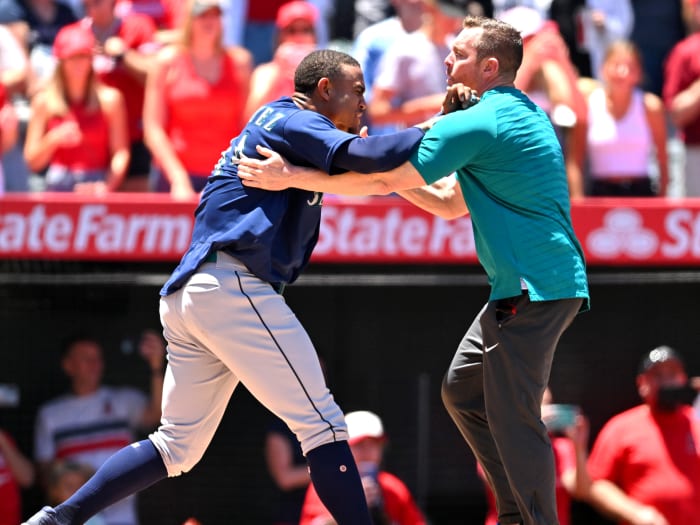 Jun 26, 2022; Anaheim, California, USA;  Seattle Mariners strength coach James Clifford holds back center fielder Julio Rodriguez (44) during a benches clearing brawl with the Los Angeles Angels in the second inning at Angel Stadium.