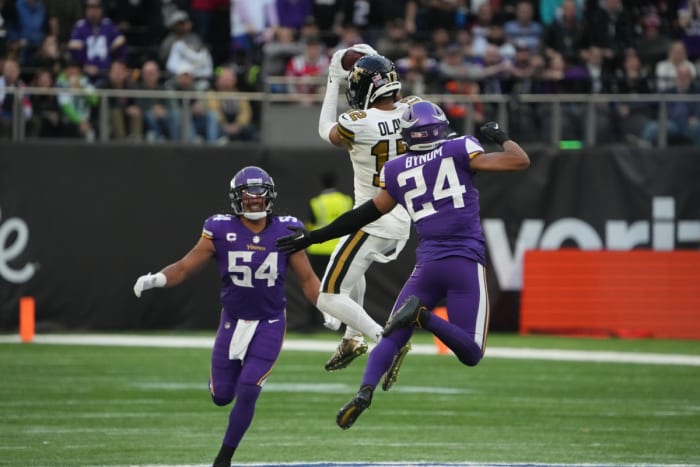 Oct 2, 2022; New Orleans Saints wide receiver Chris Olave (12) catches the ball as Minnesota Vikings safety Camryn Bynum (24) and linebacker Eric Kendricks (54) defend. Mandatory Credit: Kirby Lee-USA TODAY Sports