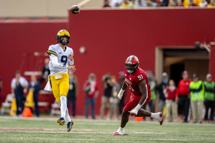 Bloomington, Indiana, USA; Michigan Wolverines quarterback J.J. McCarthy (9) throws a pass away from Indiana Hoosiers defensive lineman LeDarrius Cox (91) during the second half at Memorial Stadium. Wolverines won 31 to 10.