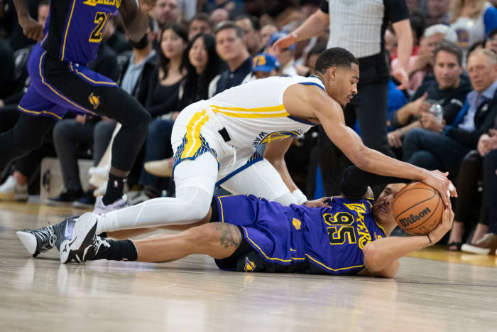 Warriors guard Jordan Poole and Lakers forward Juan Toscano-Anderson battle for the ball.