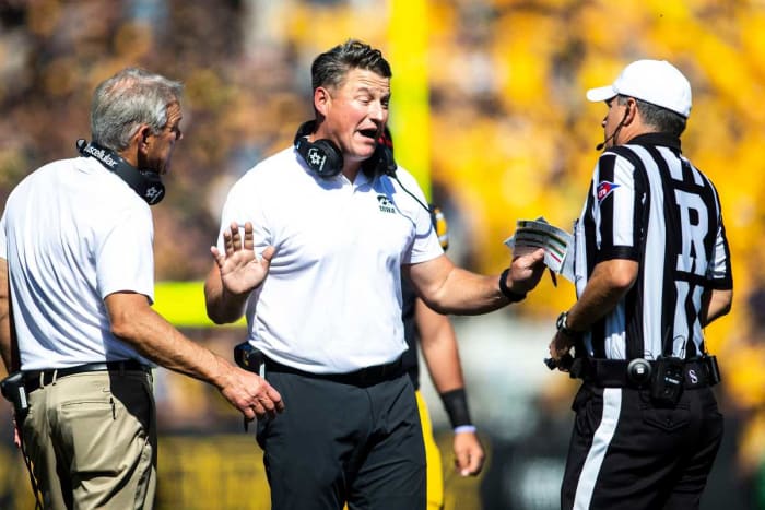 Iowa coaches Kirk and Brian Ferentz talk to a referee