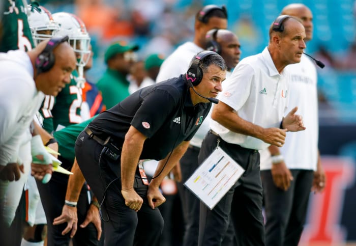 Miami head coach Mario Cristobal leans over with his hands on his knees