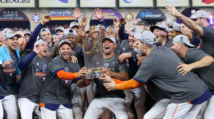 Astros celebrate while holding the World Series trophy