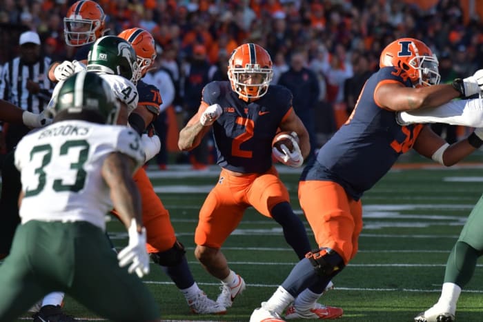 November 5, 2022;  Champaign, Illinois, USA;  Illinois Fighting Illini running back Chase Brown (2) goes through an opening against the Michigan State Spartans during the first half at Memorial Stadium.