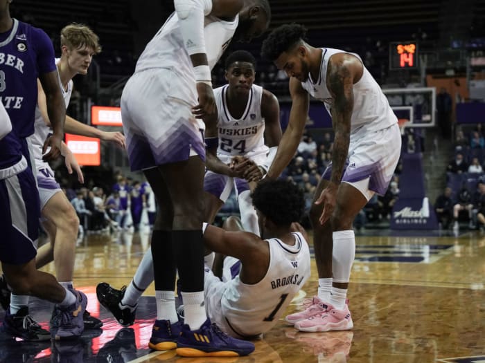 UW players rush to help Keion Brooks Jr.  to get off the ground.
