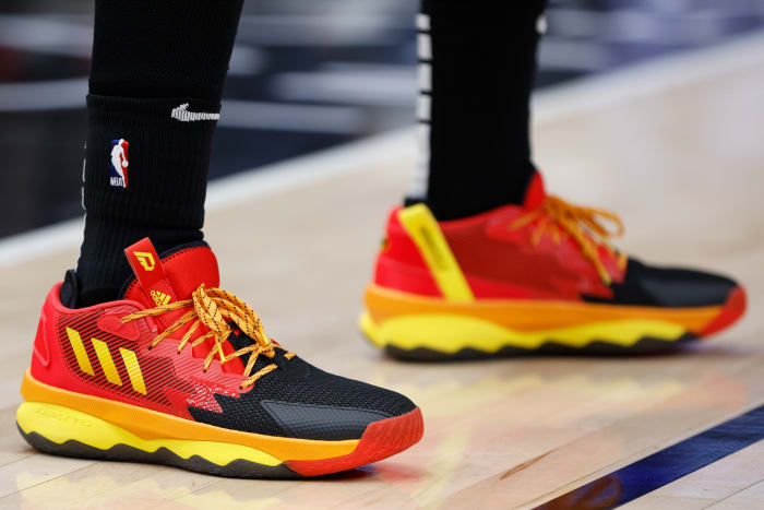 Red, black, and yellow Adidas Lady shoes.