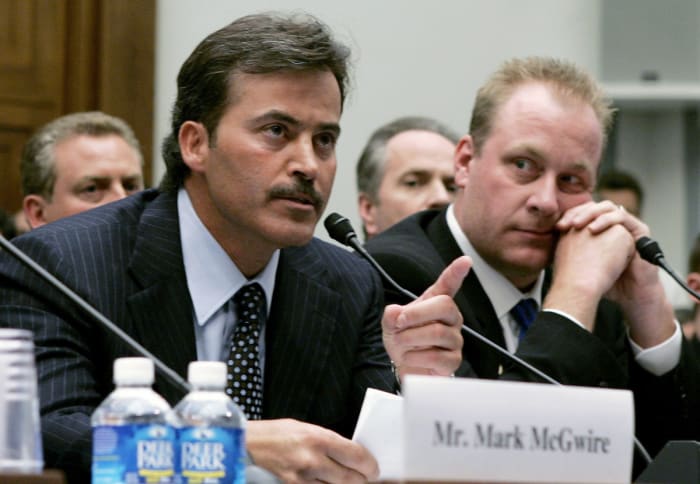 Rafael Palmeiro testifies during a Congressional hearing about the use of steroids in Major League Baseball as Curt Schilling looks on.
