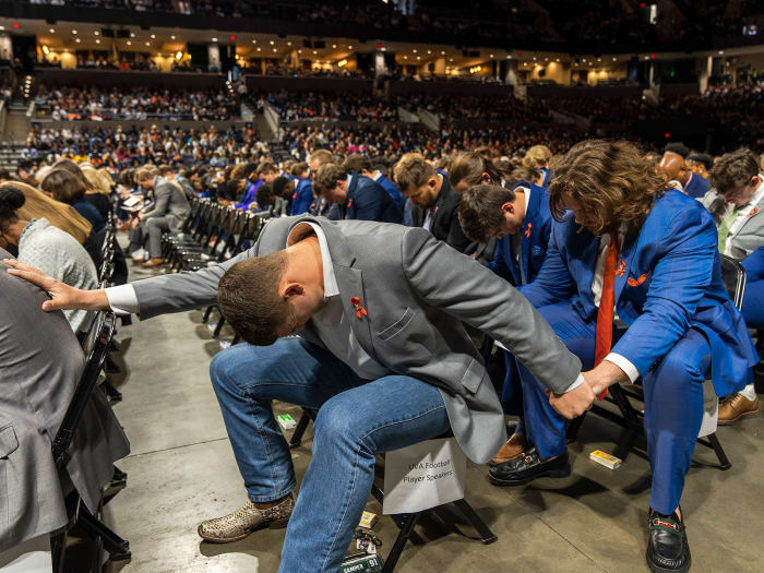 Virginia football players pray at the memorial service on Saturday